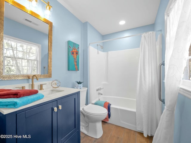 full bathroom featuring vanity, wood finished floors, visible vents, shower / bath combo with shower curtain, and toilet