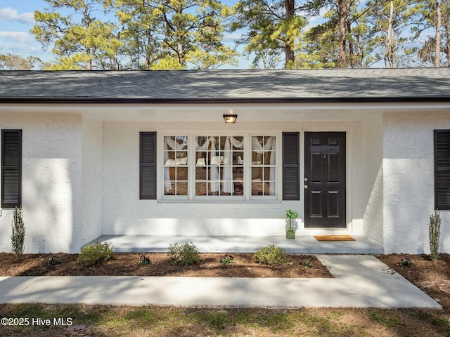 view of exterior entry featuring stucco siding