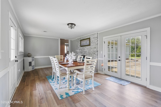 dining room with crown molding, hardwood / wood-style flooring, and french doors