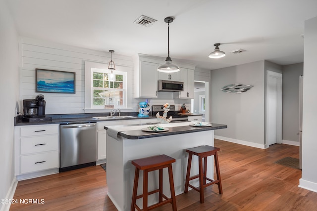 kitchen with white cabinets, appliances with stainless steel finishes, and dark hardwood / wood-style floors