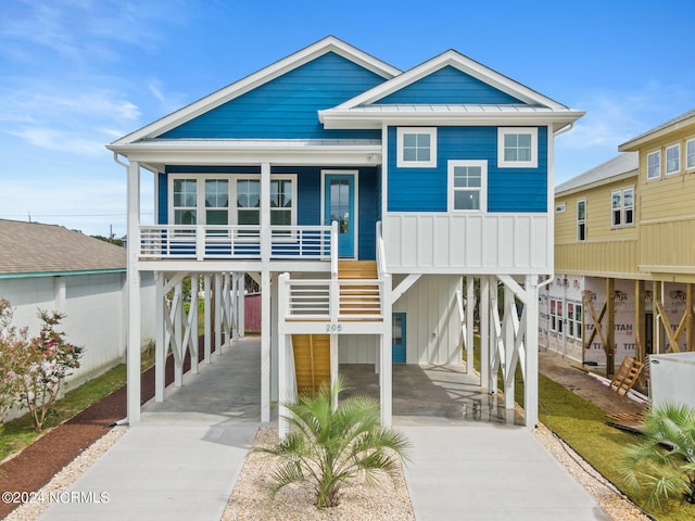 coastal home featuring a porch and a carport