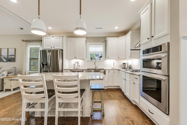 600 Planters Ridge Dr, Sunset Beach, NC 28468 - kitchen featuring backsplash, a sink, light stone counters, white cabinets, and stainless steel appliances