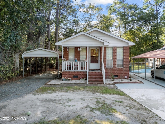 bungalow-style home with a porch and a carport