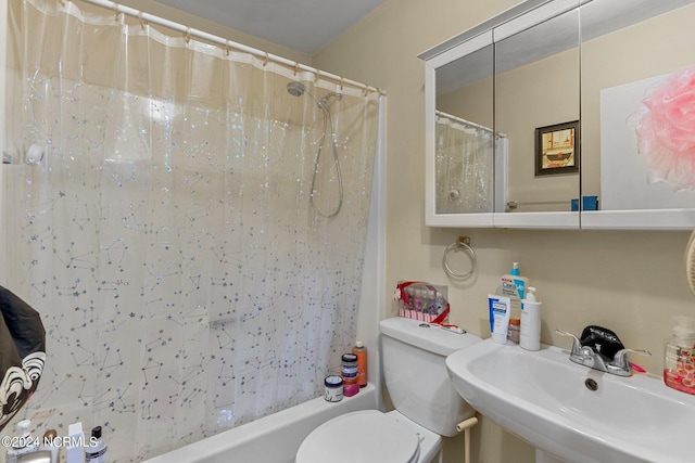 full bathroom featuring toilet, shower / bath combo with shower curtain, and a sink