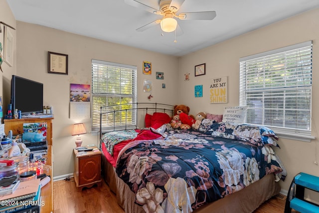 bedroom featuring ceiling fan, baseboards, and wood finished floors