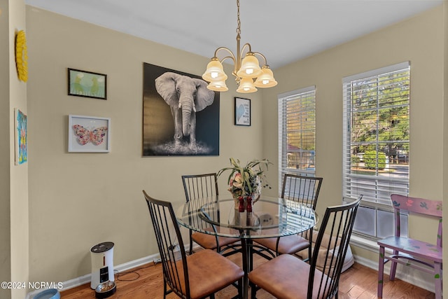 dining area featuring wood-type flooring and a chandelier