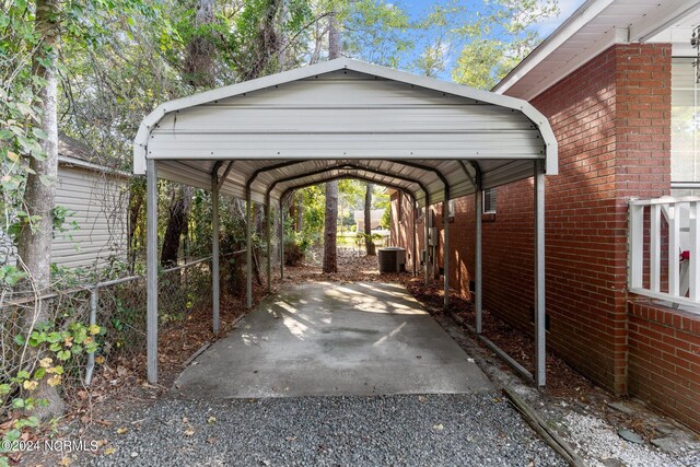 view of vehicle parking with a detached carport and gravel driveway