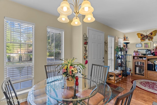 dining area with an inviting chandelier and wood finished floors