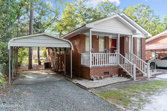 view of front of home featuring a carport, driveway, a porch, and brick siding