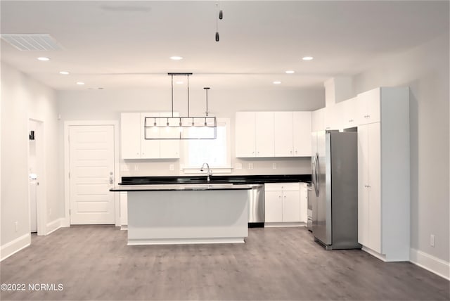 kitchen featuring dark countertops, visible vents, stainless steel appliances, and white cabinets