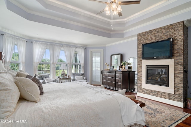 bedroom featuring a tray ceiling, crown molding, and multiple windows