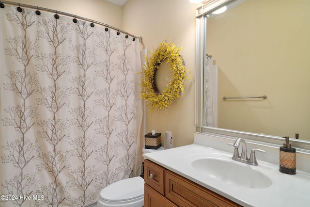 bathroom featuring vanity, toilet, and walk in shower