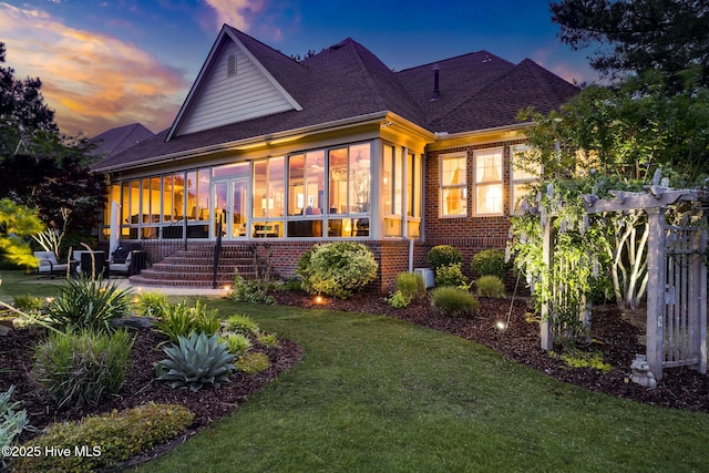 traditional home featuring concrete driveway, a shingled roof, brick siding, and a garage
