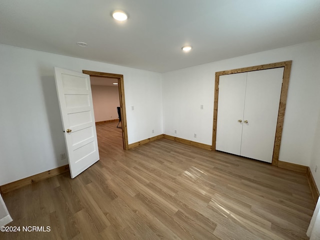 unfurnished bedroom featuring light hardwood / wood-style floors and a closet