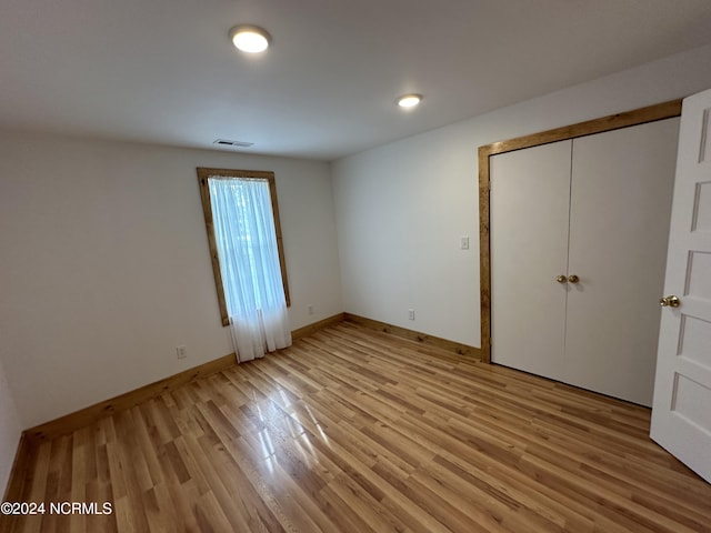 unfurnished bedroom featuring a closet and light wood-type flooring