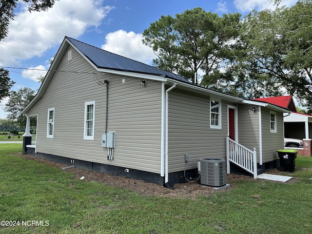 exterior space with a lawn and central AC unit