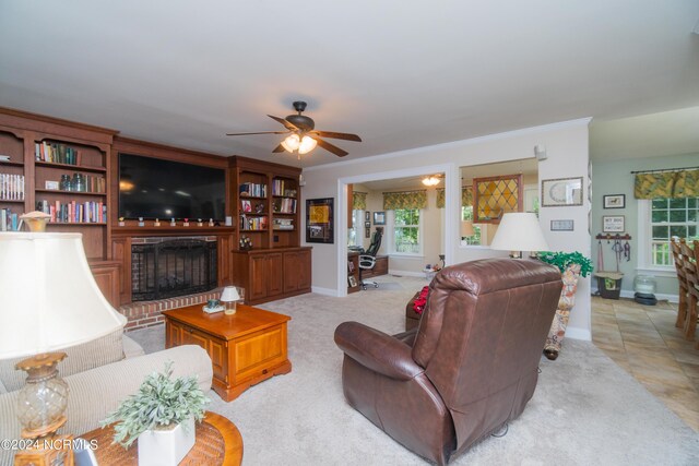 living room featuring ceiling fan, a brick fireplace, and light tile patterned flooring