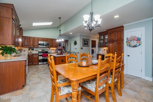 tiled dining area with lofted ceiling with skylight, washer / dryer, and a chandelier