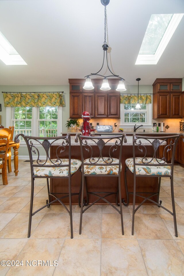 dining area with light tile patterned flooring and a skylight