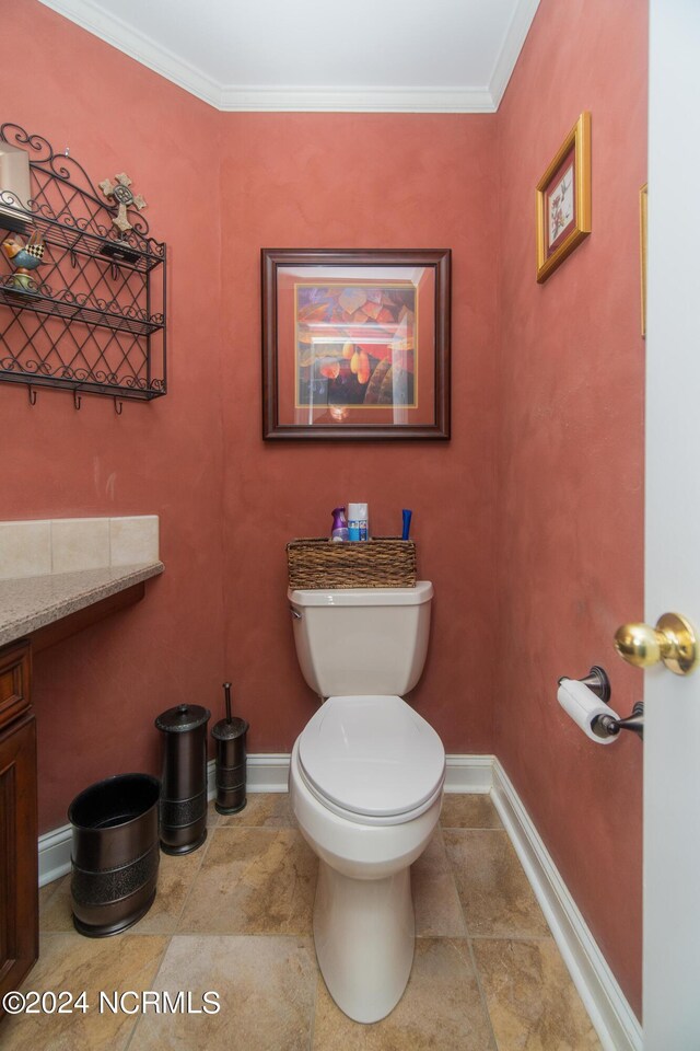 bathroom with crown molding, toilet, and tile patterned floors