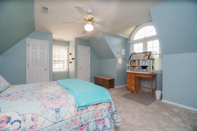 carpeted bedroom with ceiling fan, vaulted ceiling, and a textured ceiling