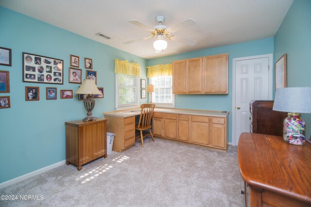 kitchen featuring a textured ceiling, ceiling fan, and light colored carpet