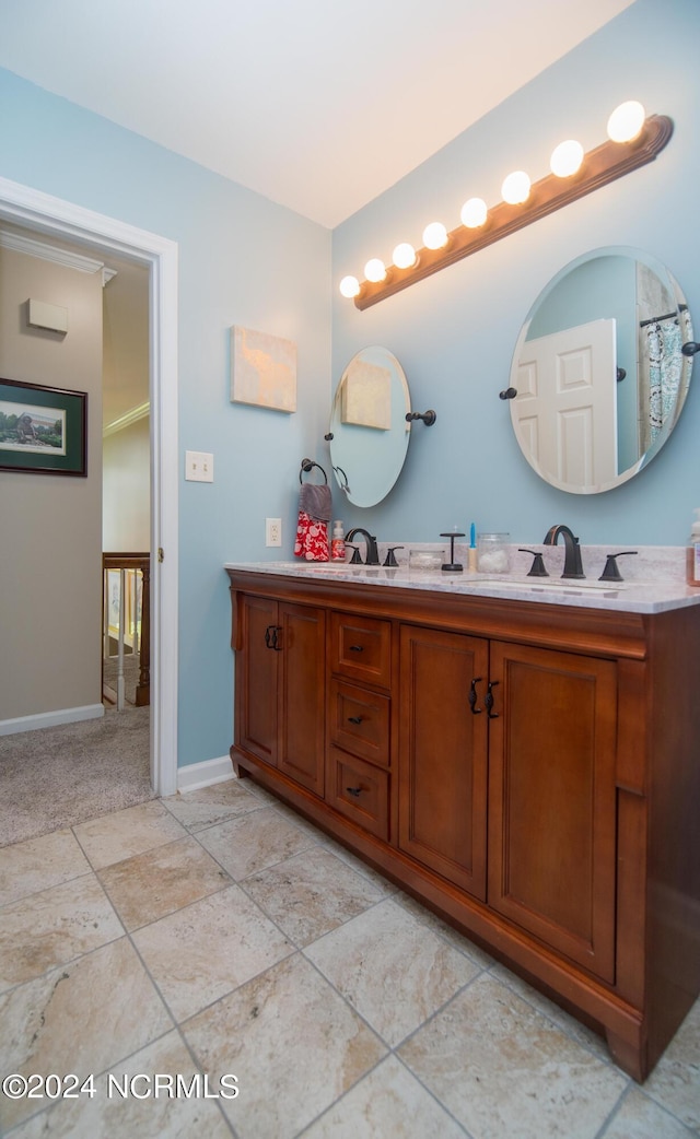 bathroom with crown molding, double vanity, and tile patterned flooring