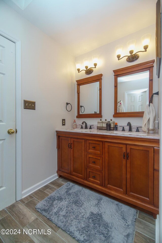 bathroom with hardwood / wood-style floors and dual bowl vanity