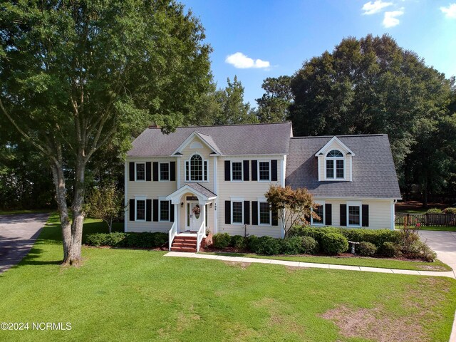 colonial inspired home featuring a front yard