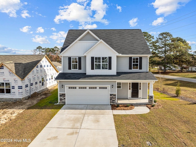 view of front facade featuring a garage, covered porch, and a front lawn