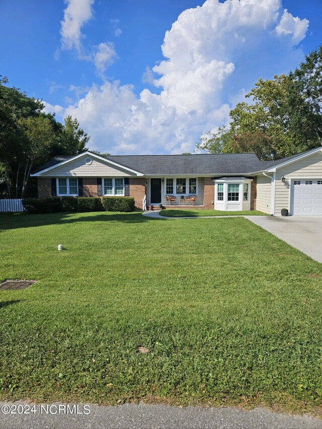 single story home with a garage and a front lawn