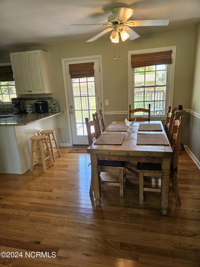 dining space with ceiling fan and light hardwood / wood-style flooring