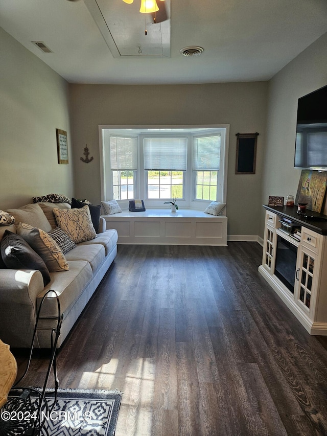 living room with plenty of natural light, dark wood finished floors, visible vents, and attic access