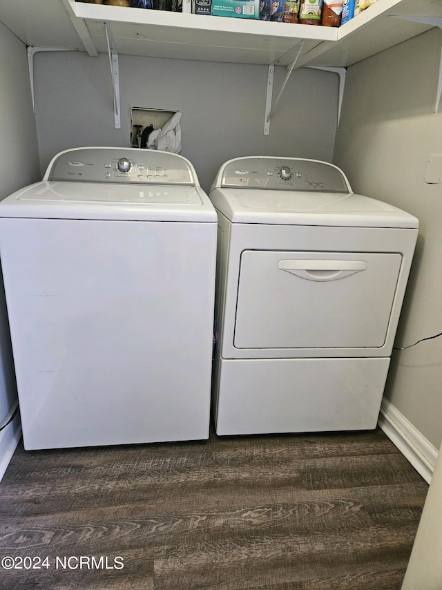 clothes washing area featuring washing machine and clothes dryer and dark hardwood / wood-style floors