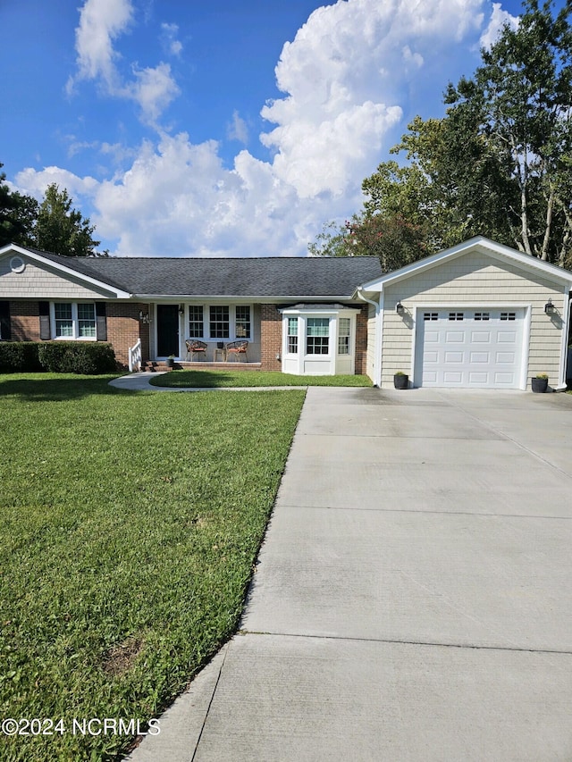 single story home featuring concrete driveway, a front lawn, a shingled roof, and brick siding