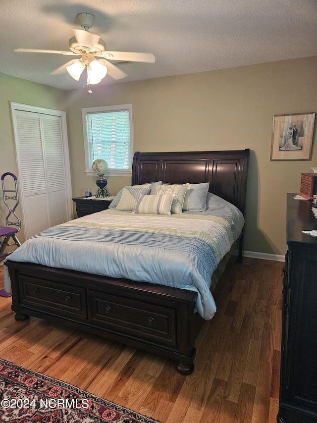 bedroom featuring ceiling fan, dark hardwood / wood-style floors, a textured ceiling, and a closet