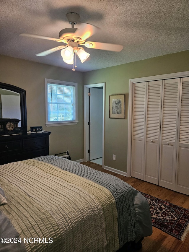 bedroom featuring ceiling fan, wood-type flooring, a textured ceiling, and a closet