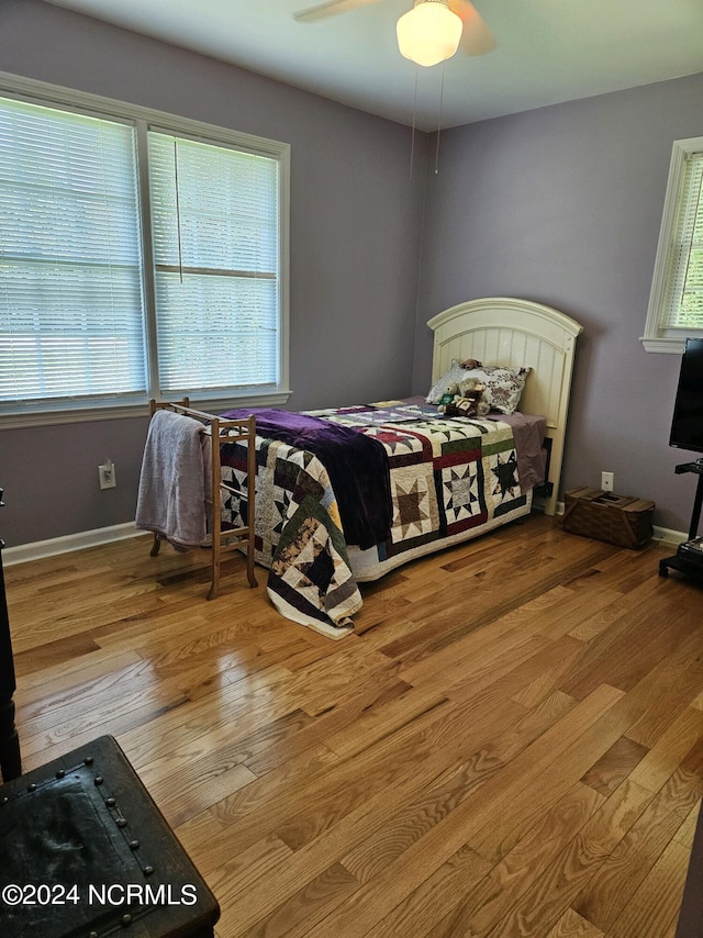 bedroom with baseboards, a ceiling fan, and light wood-style floors