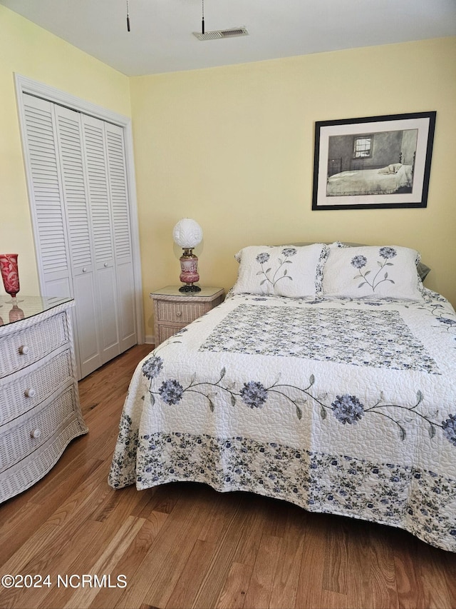 bedroom featuring wood-type flooring and a closet