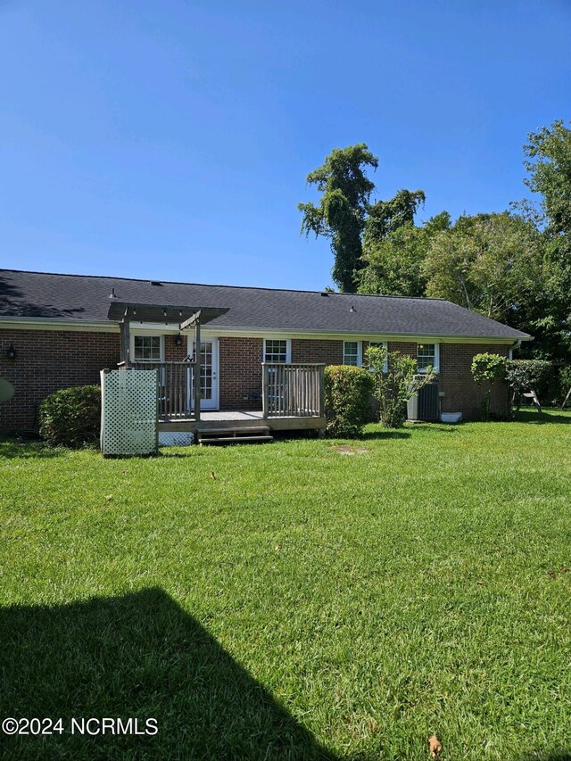 single story home with a deck and a front lawn