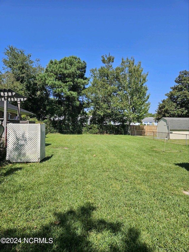 view of yard with a shed and fence