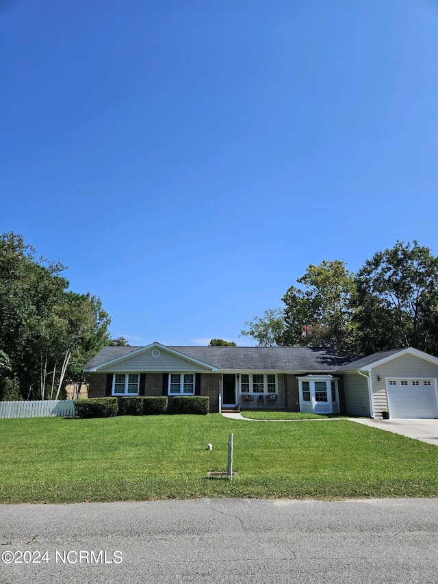 ranch-style home featuring a garage and a front yard