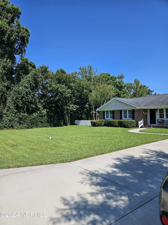 view of front of home with brick siding and a front yard