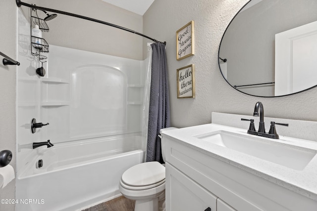 full bath with vanity, shower / tub combo, toilet, and a textured wall