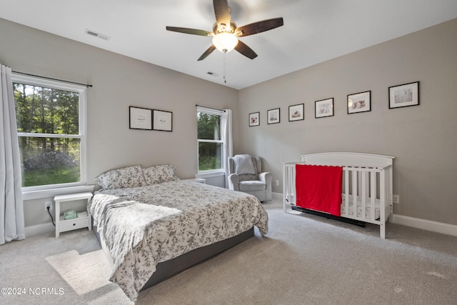 carpeted bedroom featuring a ceiling fan, baseboards, and visible vents