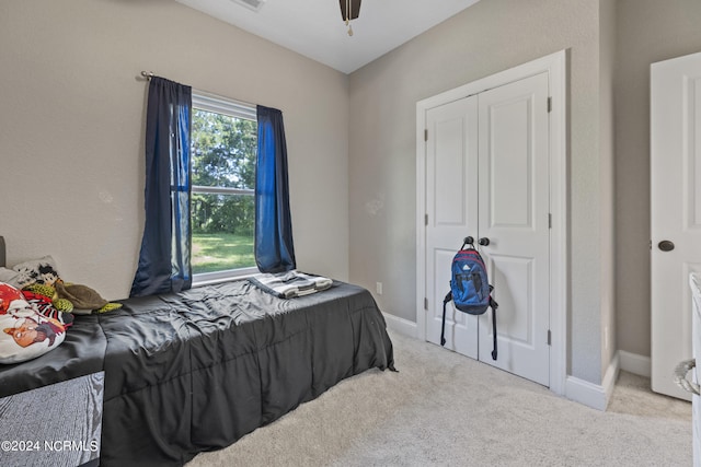 carpeted bedroom with visible vents, baseboards, and ceiling fan