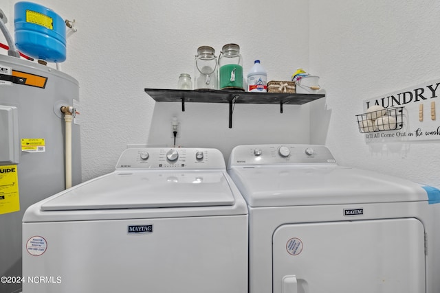 laundry area featuring laundry area, electric water heater, a textured wall, and separate washer and dryer