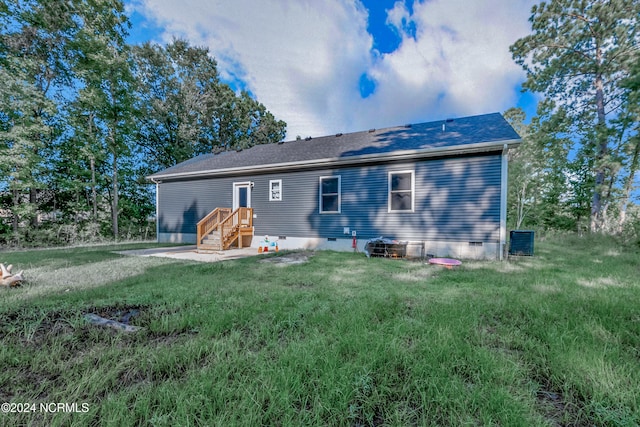 rear view of property featuring a lawn, roof with shingles, and crawl space