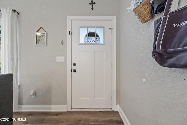 entryway featuring baseboards, dark wood-style floors, and a textured wall