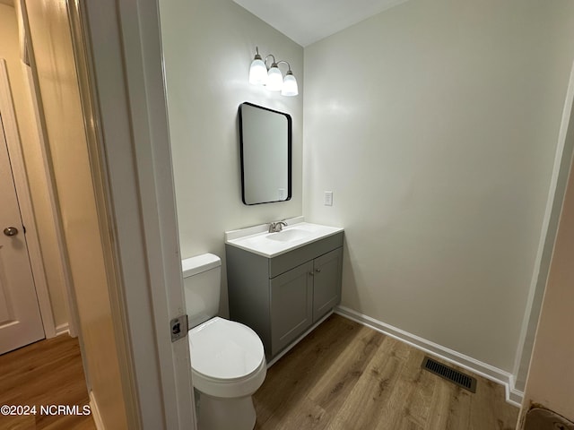 bathroom featuring vanity, toilet, and hardwood / wood-style flooring